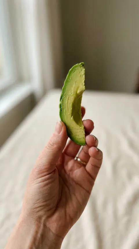 A thick spear of avocado held for a six-month-old
